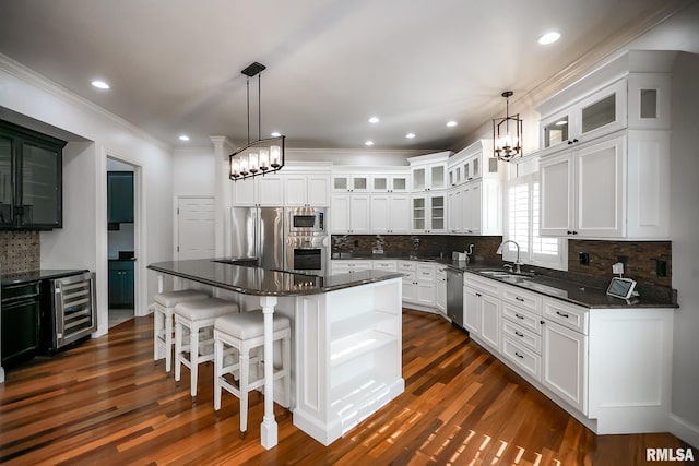 kitchen with stainless steel appliances, a chandelier, beverage cooler, and a sink