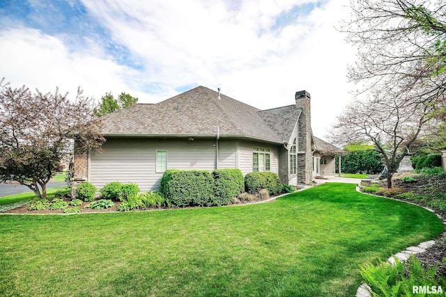 view of home's exterior with a chimney and a lawn
