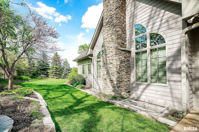 view of side of property with a chimney, stone siding, and a lawn