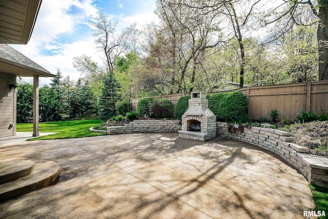 view of patio / terrace with an outdoor stone fireplace and fence