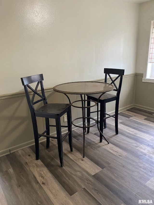 dining area with baseboards and wood finished floors