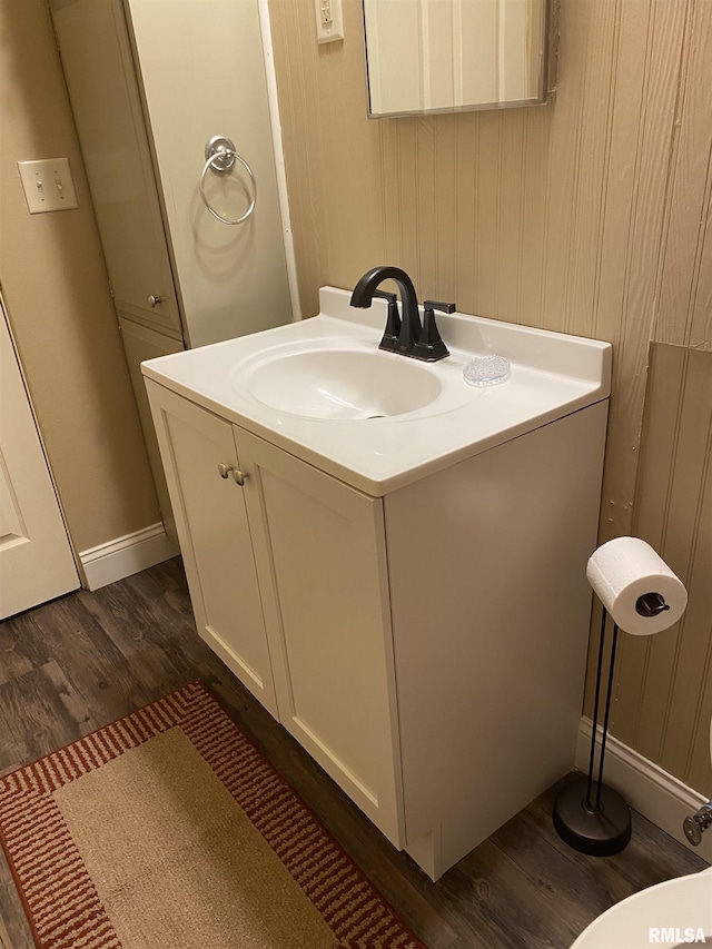 bathroom featuring vanity, baseboards, and wood finished floors