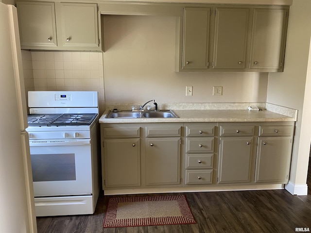 kitchen featuring light countertops, dark wood-style floors, a sink, and white appliances