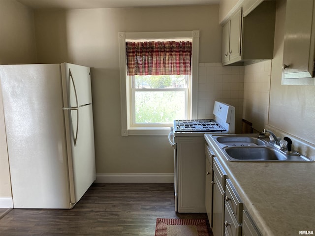 kitchen with baseboards, white appliances, a sink, light countertops, and dark wood-style floors
