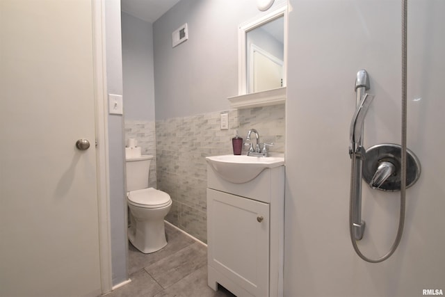 420 W Garfield Ave, Bartonville, IL 61607 - bathroom with vanity, toilet, tile walls, tile patterned floors, and wainscoting