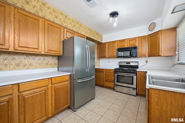 1420 N 10th St, Pekin, IL 61554 - kitchen with a sink, brown cabinets, light tile patterned flooring, visible vents, and appliances with stainless steel finishes
