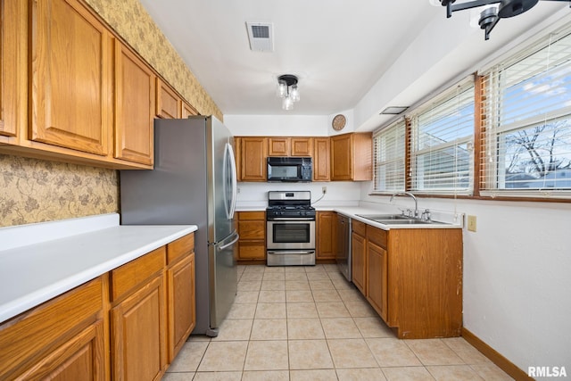 1420 N 10th St, Pekin, IL 61554 - kitchen featuring brown cabinets, a sink, visible vents, light countertops, and appliances with stainless steel finishes