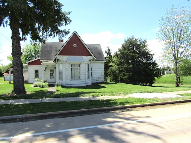 906 E Broadway St, Astoria, IL 61501 - view of front of home featuring a front lawn, a shingled roof, and a chimney