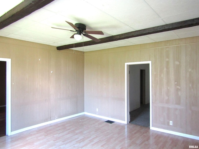 906 E Broadway St, Astoria, IL 61501 - empty room featuring wooden walls, wood finished floors, baseboards, and ceiling fan