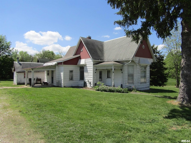 906 E Broadway St, Astoria, IL 61501 - back of house featuring a shingled roof, a chimney, and a lawn