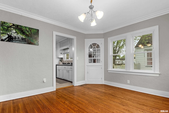 2714 W Kenwood Ave, West Peoria, IL 61604 - unfurnished dining area with a chandelier, a textured wall, light wood-style flooring, baseboards, and a sink