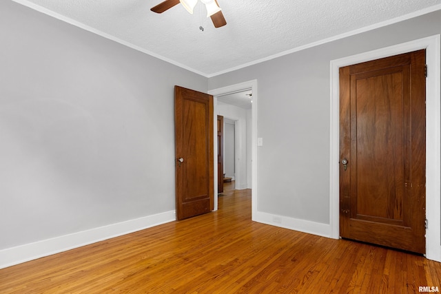 2714 W Kenwood Ave, West Peoria, IL 61604 - unfurnished room with a ceiling fan, light wood-type flooring, baseboards, a textured ceiling, and crown molding