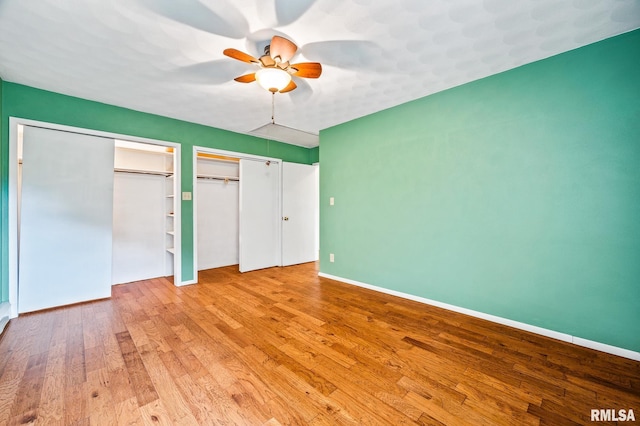 21016 N US Highway 24, Canton, IL 61520 - unfurnished bedroom with two closets, wood finished floors, baseboards, and ceiling fan