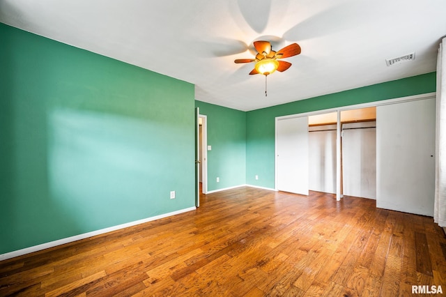 21016 N US Highway 24, Canton, IL 61520 - unfurnished bedroom featuring a closet, visible vents, baseboards, ceiling fan, and hardwood / wood-style flooring