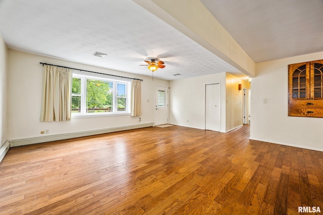 21016 N US Highway 24, Canton, IL 61520 - empty room with baseboard heating, baseboards, ceiling fan, visible vents, and wood finished floors