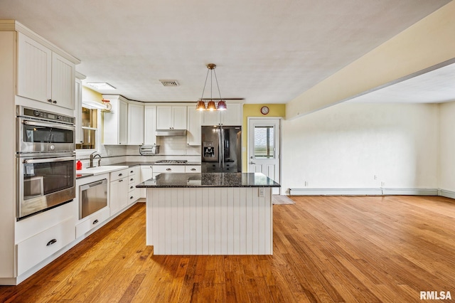 21016 N US Highway 24, Canton, IL 61520 - kitchen with light wood finished floors, a center island, a sink, stainless steel appliances, and visible vents