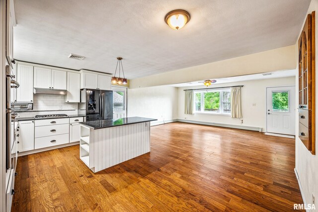 21016 N US Highway 24, Canton, IL 61520 - kitchen with open shelves, dark countertops, visible vents, a baseboard heating unit, and appliances with stainless steel finishes