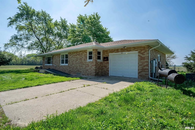 view of front of home featuring an attached garage, brick siding, driveway, and a front lawn