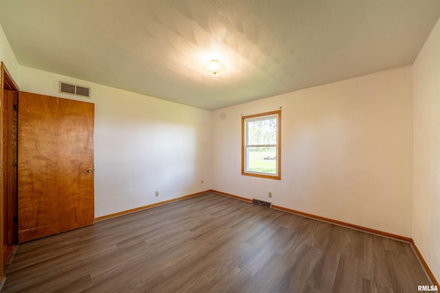 empty room with wood finished floors and baseboards