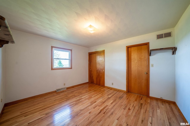 unfurnished bedroom featuring light wood-type flooring and baseboards
