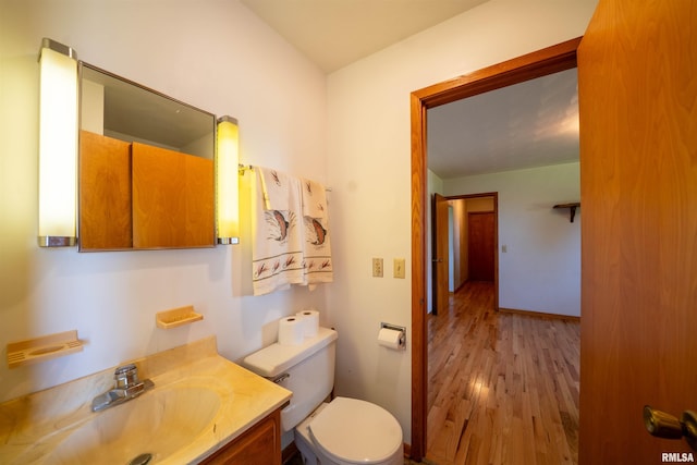 bathroom featuring wood finished floors, vanity, and toilet