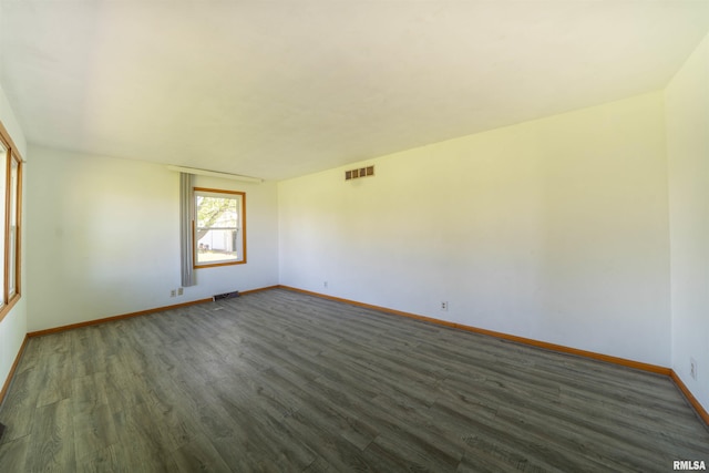 empty room featuring dark wood finished floors and baseboards