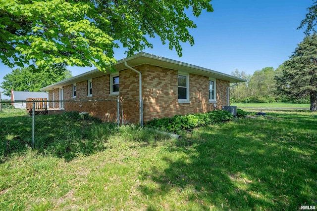 view of side of home featuring brick siding and central AC unit
