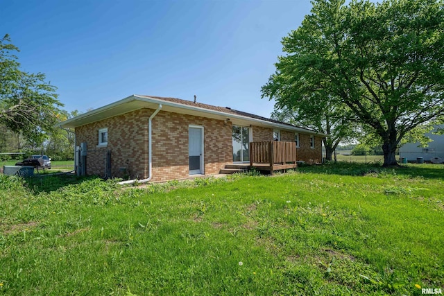 back of property featuring a wooden deck and brick siding