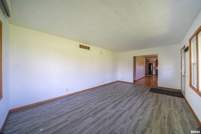 spare room featuring dark wood finished floors and baseboards