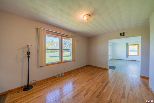spare room with light wood-style flooring and baseboards