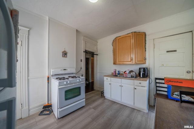 1624 W Barker Ave, Peoria, IL 61606 - kitchen with white range with gas stovetop, light wood-style flooring, ornamental molding, a sink, and light countertops