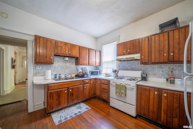 1624 W Barker Ave, Peoria, IL 61606 - kitchen featuring white gas range oven, stainless steel microwave, a sink, under cabinet range hood, and dark wood-style flooring