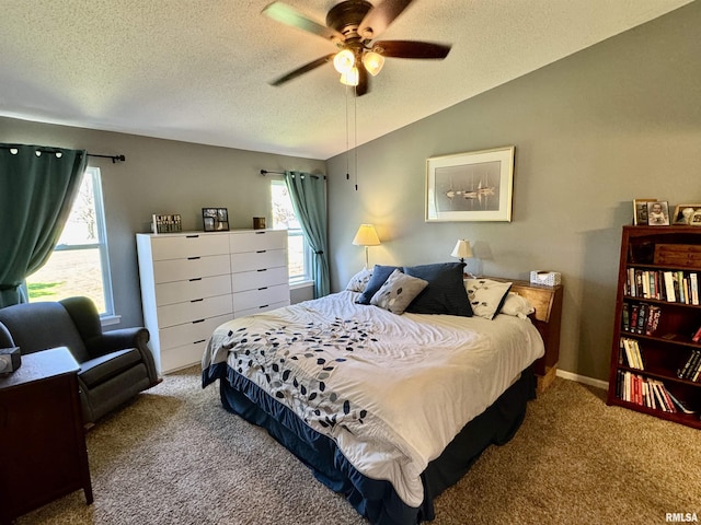 carpeted bedroom featuring a textured ceiling, vaulted ceiling, and a ceiling fan