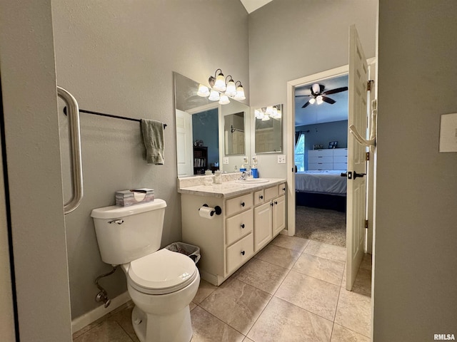 ensuite bathroom with toilet, tile patterned flooring, vanity, ceiling fan, and a high ceiling