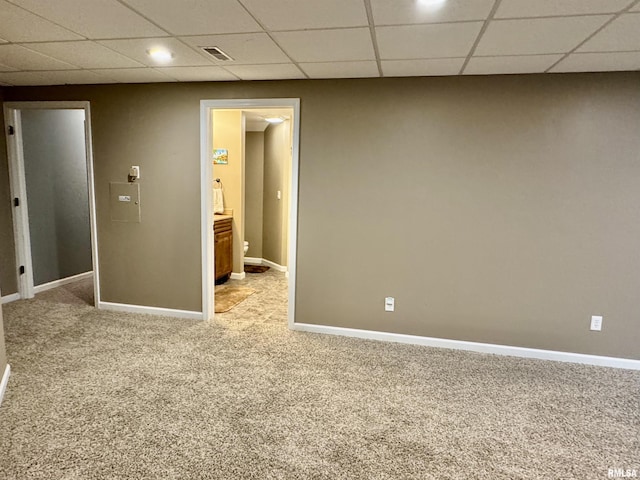 unfurnished room with carpet floors, a drop ceiling, and baseboards