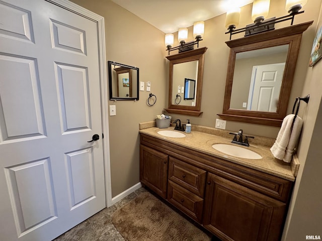 full bathroom featuring baseboards and double vanity