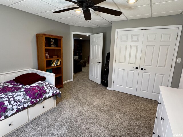 carpeted bedroom featuring a closet, a paneled ceiling, and ceiling fan