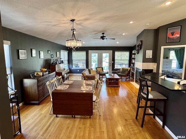 dining space featuring light wood-style floors, a ceiling fan, a textured ceiling, recessed lighting, and baseboards