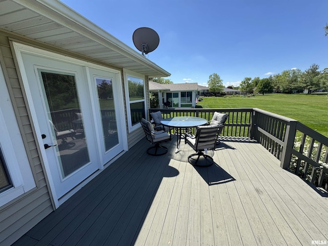 deck with a lawn and outdoor dining area