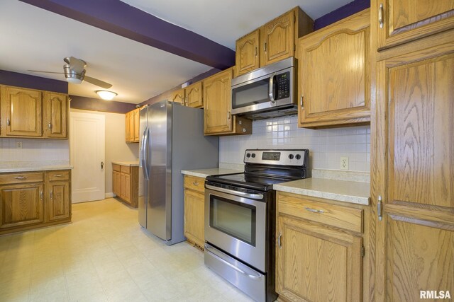 606 W Maywood Ave, Peoria, IL 61604 - kitchen featuring stainless steel appliances, backsplash, light countertops, light floors, and brown cabinetry