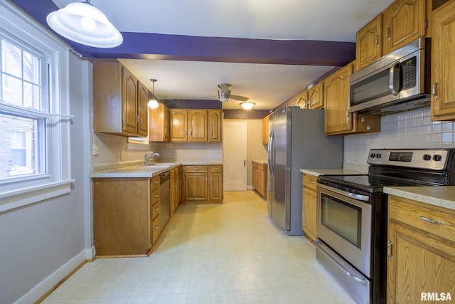 606 W Maywood Ave, Peoria, IL 61604 - kitchen with stainless steel appliances, brown cabinetry, backsplash, light countertops, and light floors