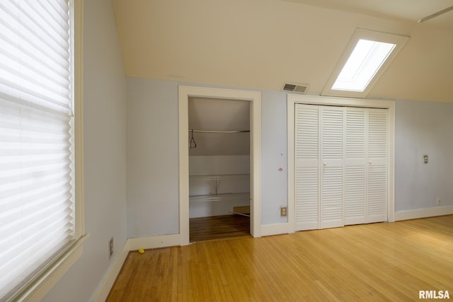 606 W Maywood Ave, Peoria, IL 61604 - unfurnished bedroom featuring light wood finished floors, a skylight, vaulted ceiling, and a closet