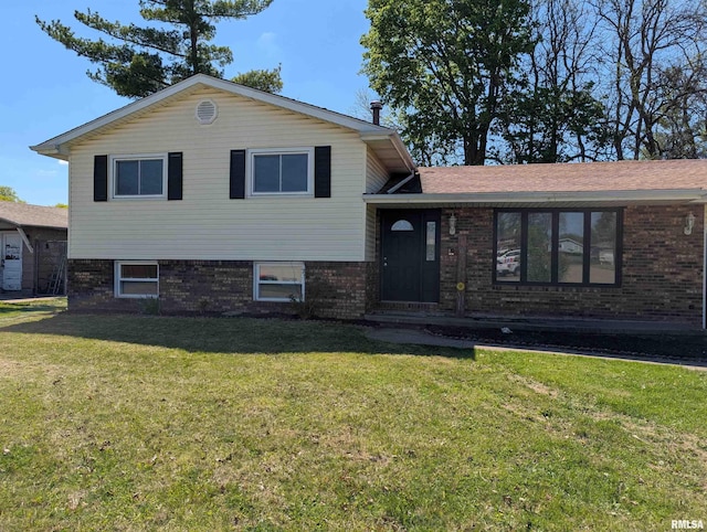 split level home with a front lawn and brick siding