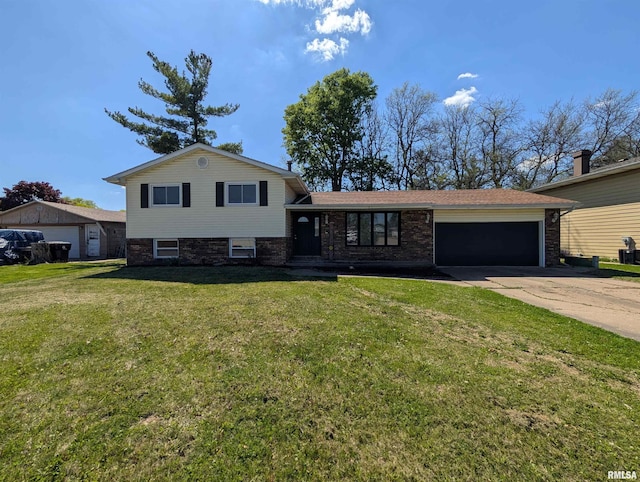 tri-level home with an attached garage, concrete driveway, a front yard, and brick siding