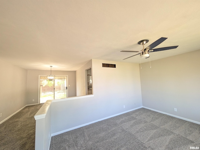 unfurnished room with carpet floors, a ceiling fan, and baseboards