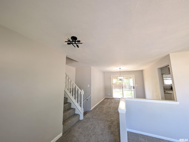 stairs featuring baseboards, carpet floors, and a chandelier