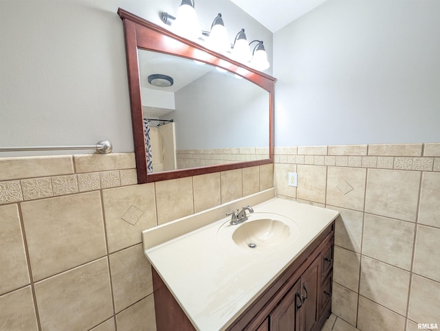 bathroom with tile walls, vanity, and a wainscoted wall
