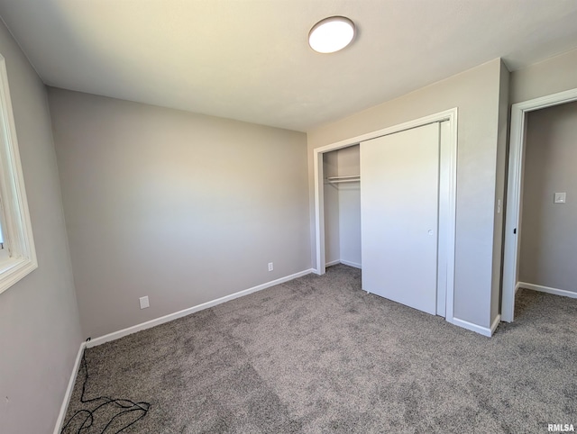 unfurnished bedroom with carpet flooring, baseboards, and a closet