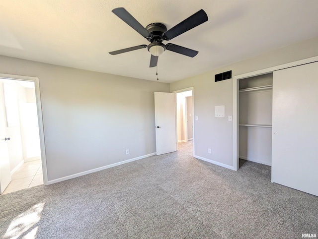 unfurnished bedroom featuring light colored carpet, a closet, a ceiling fan, and baseboards