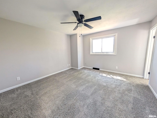 carpeted empty room featuring ceiling fan and baseboards